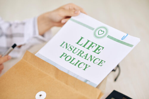 Crop worker of agency holding paper document of life insurance policy in envelope