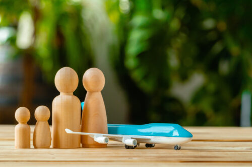 Family travel and vacation concept. Wooden figures of family and toy plane close up