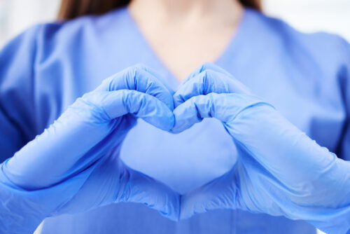 Woman, doctor and hands in heart emoji for healthcare, life insurance or sign on mockup at hospital.